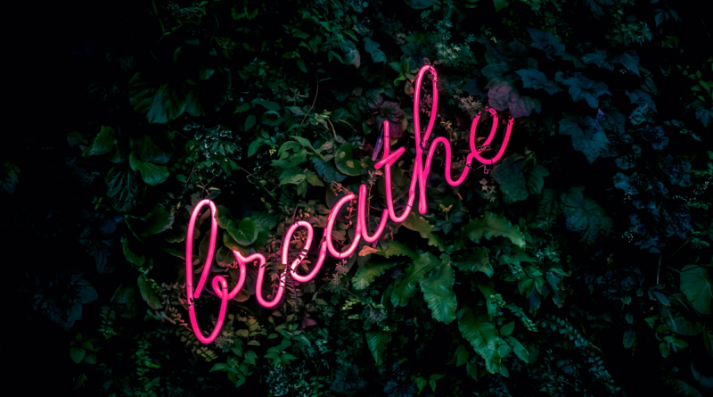 neon sign saying "breathe" for financial anxiety after being poor